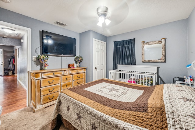 bedroom featuring hardwood / wood-style flooring, ceiling fan, and a closet