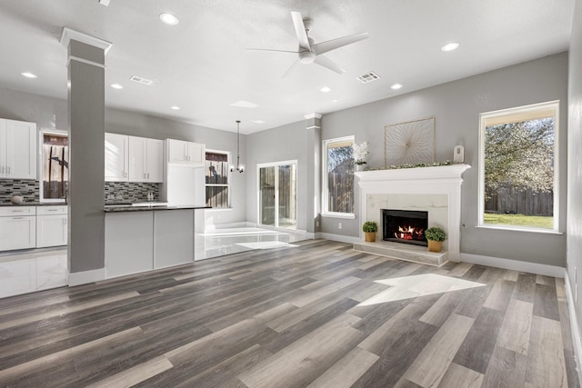 unfurnished living room featuring recessed lighting, visible vents, wood finished floors, and a fireplace