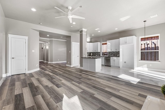 unfurnished living room featuring recessed lighting, visible vents, ceiling fan with notable chandelier, and light wood-style flooring