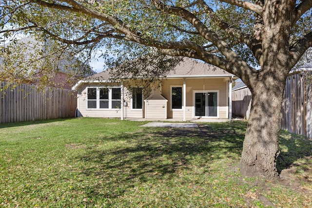 back of house featuring a yard and a fenced backyard