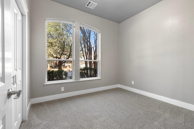 unfurnished room with visible vents, baseboards, and carpet