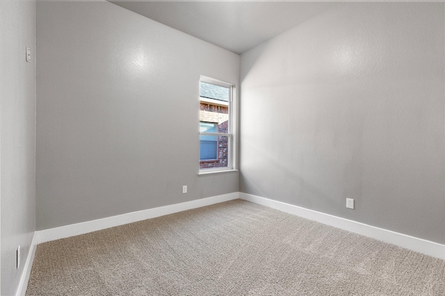 carpeted empty room with baseboards