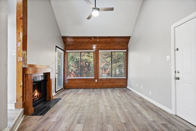 unfurnished living room featuring ceiling fan, light wood-type flooring, and high vaulted ceiling