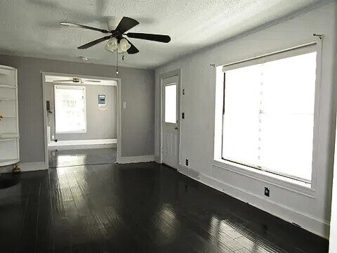 foyer entrance with a textured ceiling, ceiling fan, and dark hardwood / wood-style floors