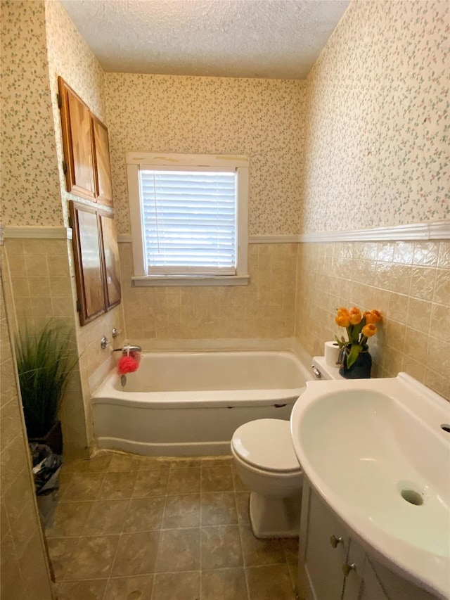 bathroom featuring a textured ceiling, toilet, and tile walls