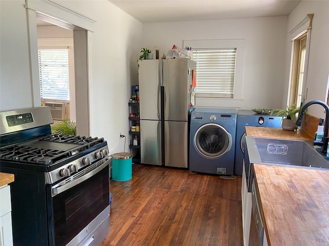 kitchen with wood counters, washer / dryer, stainless steel appliances, and dark hardwood / wood-style floors