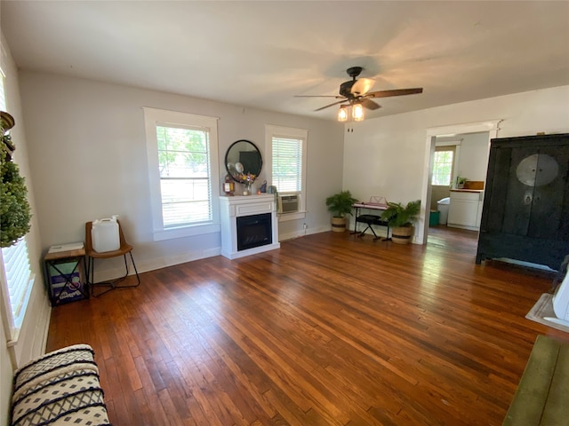 living room with ceiling fan, a healthy amount of sunlight, dark wood-type flooring, and cooling unit