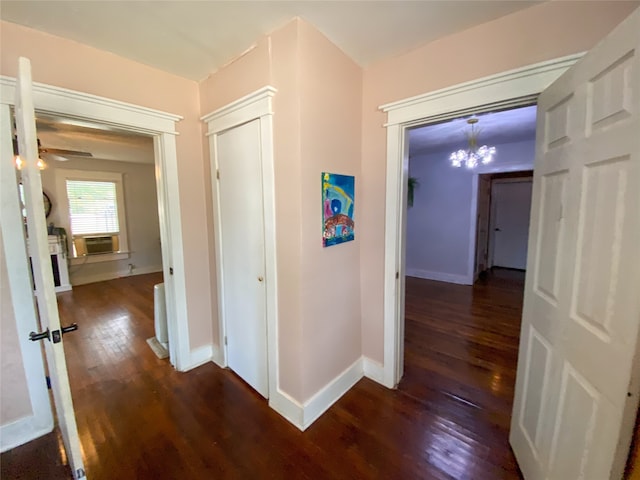 hall featuring dark hardwood / wood-style flooring and an inviting chandelier