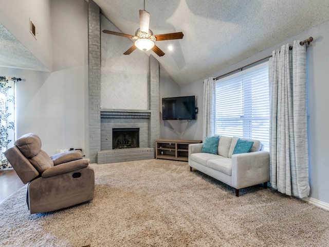 living room featuring ceiling fan, high vaulted ceiling, carpet floors, a textured ceiling, and a fireplace