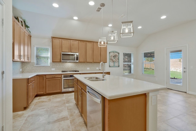 kitchen featuring appliances with stainless steel finishes, tasteful backsplash, vaulted ceiling, a healthy amount of sunlight, and pendant lighting