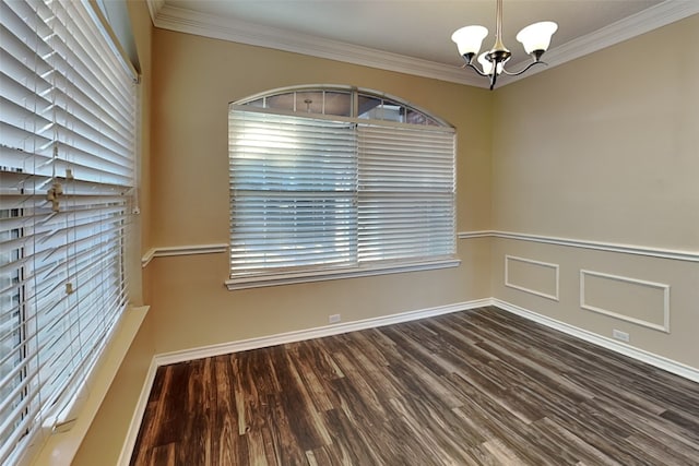 empty room with a chandelier, dark wood-type flooring, and ornamental molding