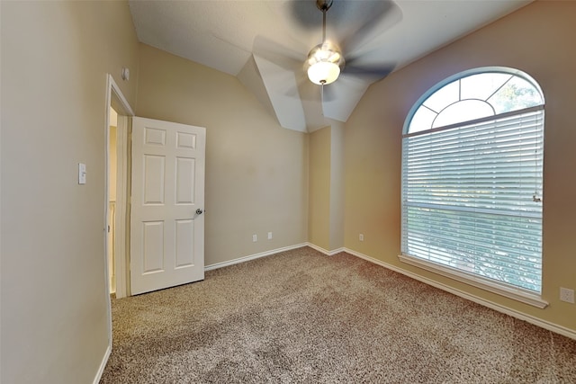 spare room featuring ceiling fan, carpet floors, and vaulted ceiling