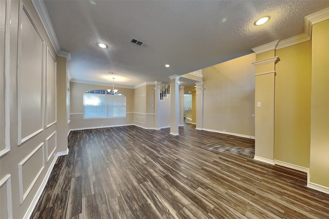 empty room featuring ornate columns, dark wood-style floors, and ornamental molding