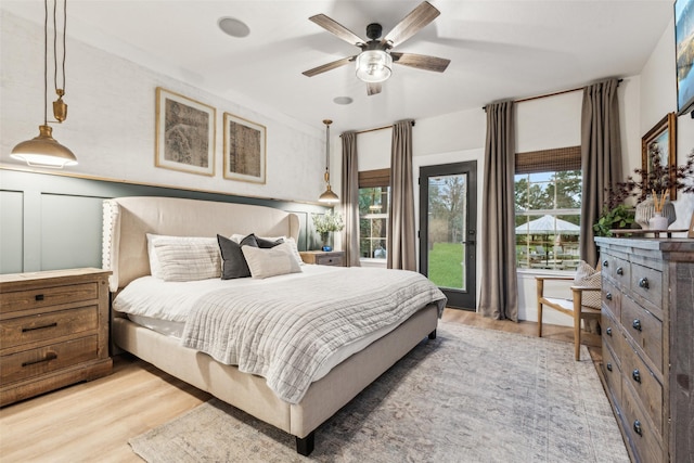 bedroom with a ceiling fan, access to exterior, and light wood finished floors
