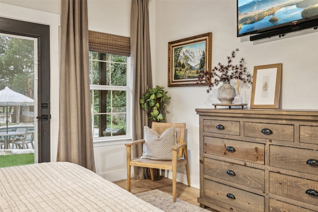 bedroom featuring multiple windows, access to exterior, and light wood-type flooring