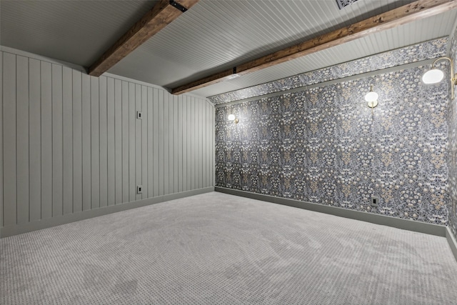 empty room featuring carpet floors and beam ceiling