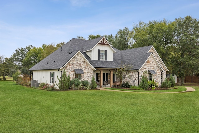 view of front of home with stone siding, a front yard, and central AC unit