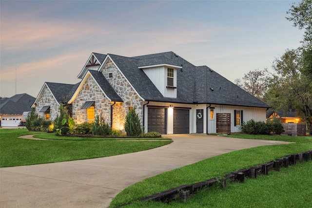 view of front of home with a garage and a lawn