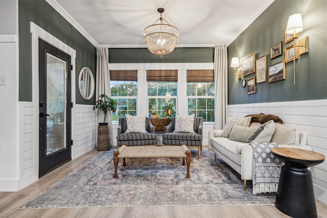 sitting room with crown molding, an inviting chandelier, and hardwood / wood-style flooring