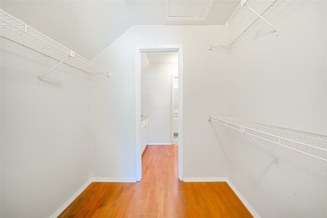 spacious closet with hardwood / wood-style flooring and vaulted ceiling