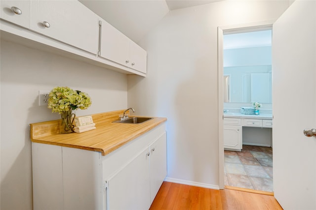 laundry area with light hardwood / wood-style flooring and sink