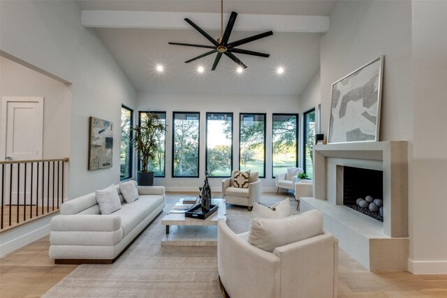 living room with beam ceiling, ceiling fan, light hardwood / wood-style flooring, and high vaulted ceiling