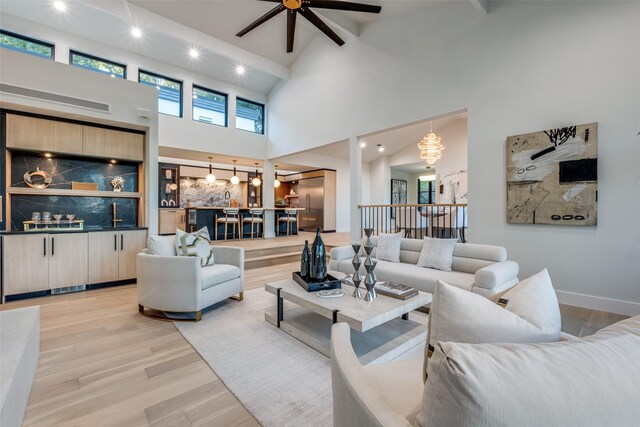 living room featuring ceiling fan, high vaulted ceiling, and light hardwood / wood-style flooring