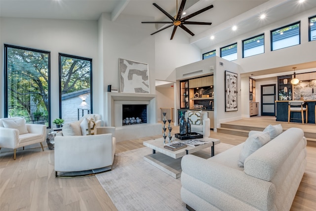 living room featuring light wood-type flooring, high vaulted ceiling, and ceiling fan