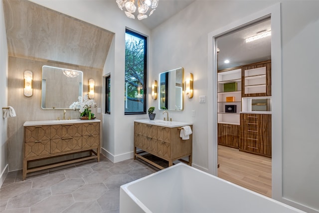 bathroom featuring a tub to relax in, vanity, wood-type flooring, an inviting chandelier, and lofted ceiling