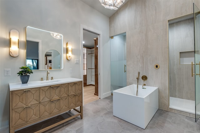 bathroom with tile patterned floors, vanity, tile walls, and shower with separate bathtub