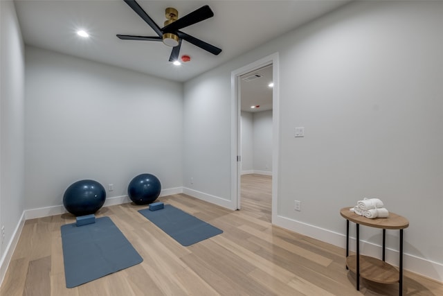 workout area featuring ceiling fan and light hardwood / wood-style flooring