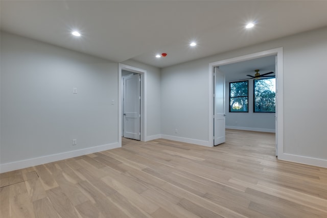 empty room with ceiling fan and light hardwood / wood-style flooring