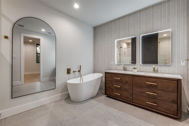 bathroom with tile patterned floors, a bathtub, and vanity