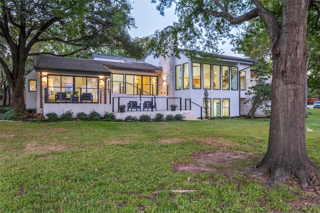 rear view of house featuring a lawn