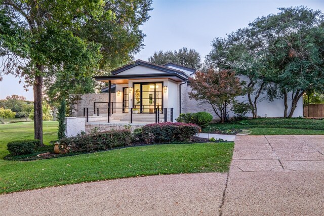 view of front of property with covered porch and a front lawn