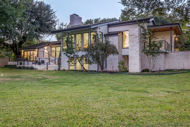 back of house featuring a lawn