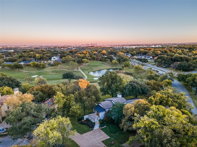 aerial view at dusk featuring a water view