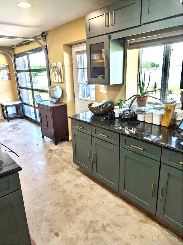 kitchen featuring a wealth of natural light and dark stone counters