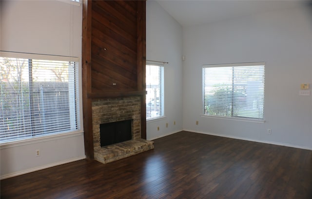 unfurnished living room with a fireplace, dark hardwood / wood-style floors, and high vaulted ceiling