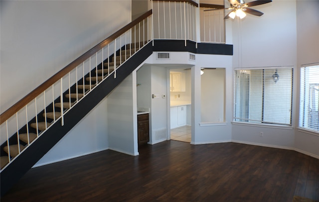 interior space featuring ceiling fan, a towering ceiling, and dark hardwood / wood-style floors