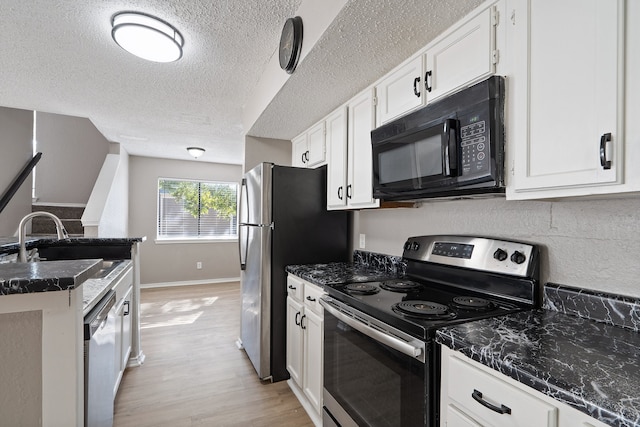 kitchen featuring a textured ceiling, stainless steel appliances, sink, light hardwood / wood-style floors, and white cabinetry