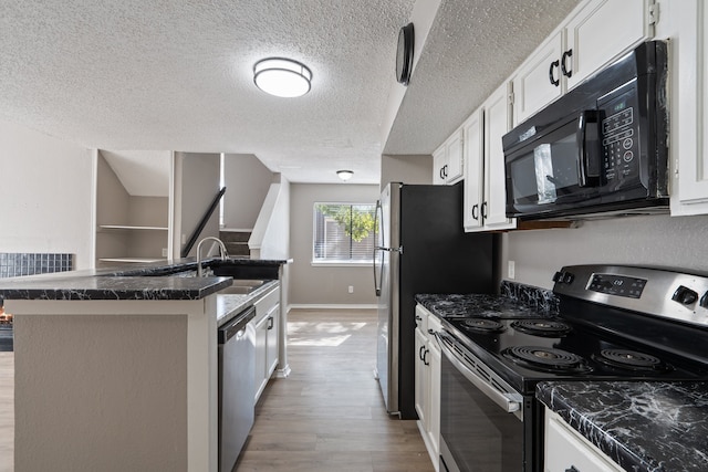 kitchen with sink, a textured ceiling, light hardwood / wood-style floors, white cabinetry, and stainless steel appliances