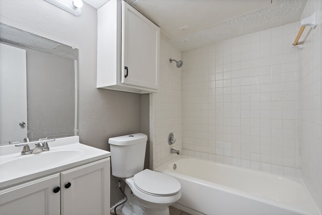 full bathroom with a textured ceiling, vanity, toilet, and tiled shower / bath