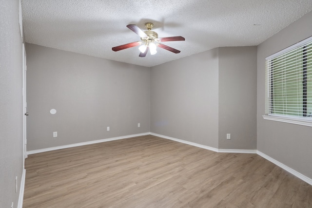 spare room featuring ceiling fan, light hardwood / wood-style floors, and a textured ceiling