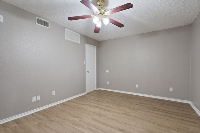 empty room featuring a textured ceiling, light wood-type flooring, and ceiling fan