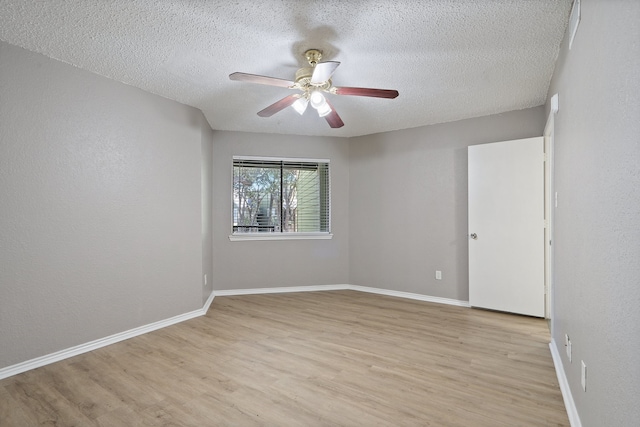 unfurnished room with ceiling fan, light wood-type flooring, and a textured ceiling