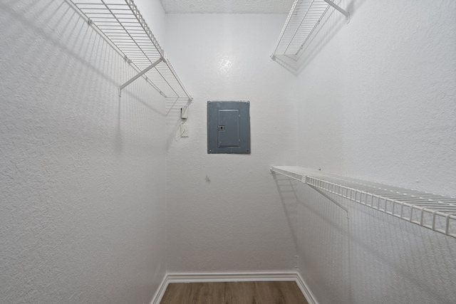 walk in closet featuring hardwood / wood-style floors and electric panel