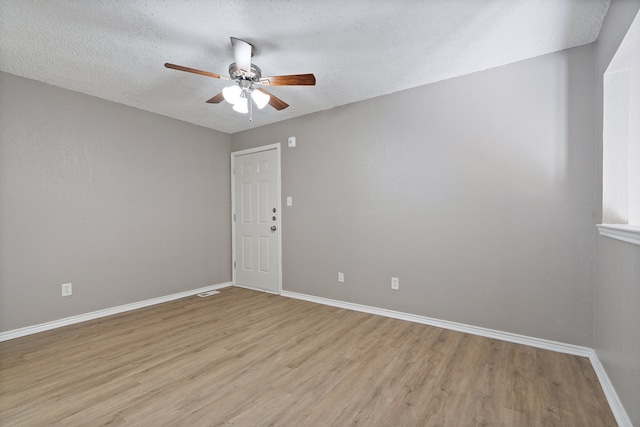 spare room featuring ceiling fan, a textured ceiling, and light wood-type flooring