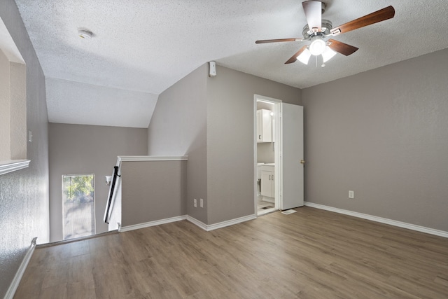 bonus room featuring a textured ceiling, hardwood / wood-style flooring, vaulted ceiling, and ceiling fan