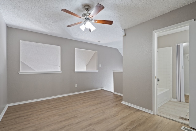 bonus room with a textured ceiling, light hardwood / wood-style flooring, and ceiling fan